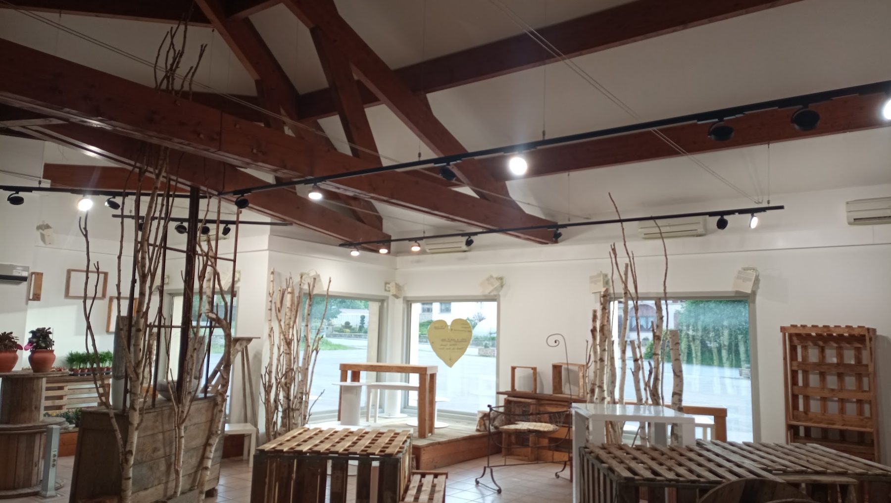Boutique éclairée par des rails de spots sous charpente